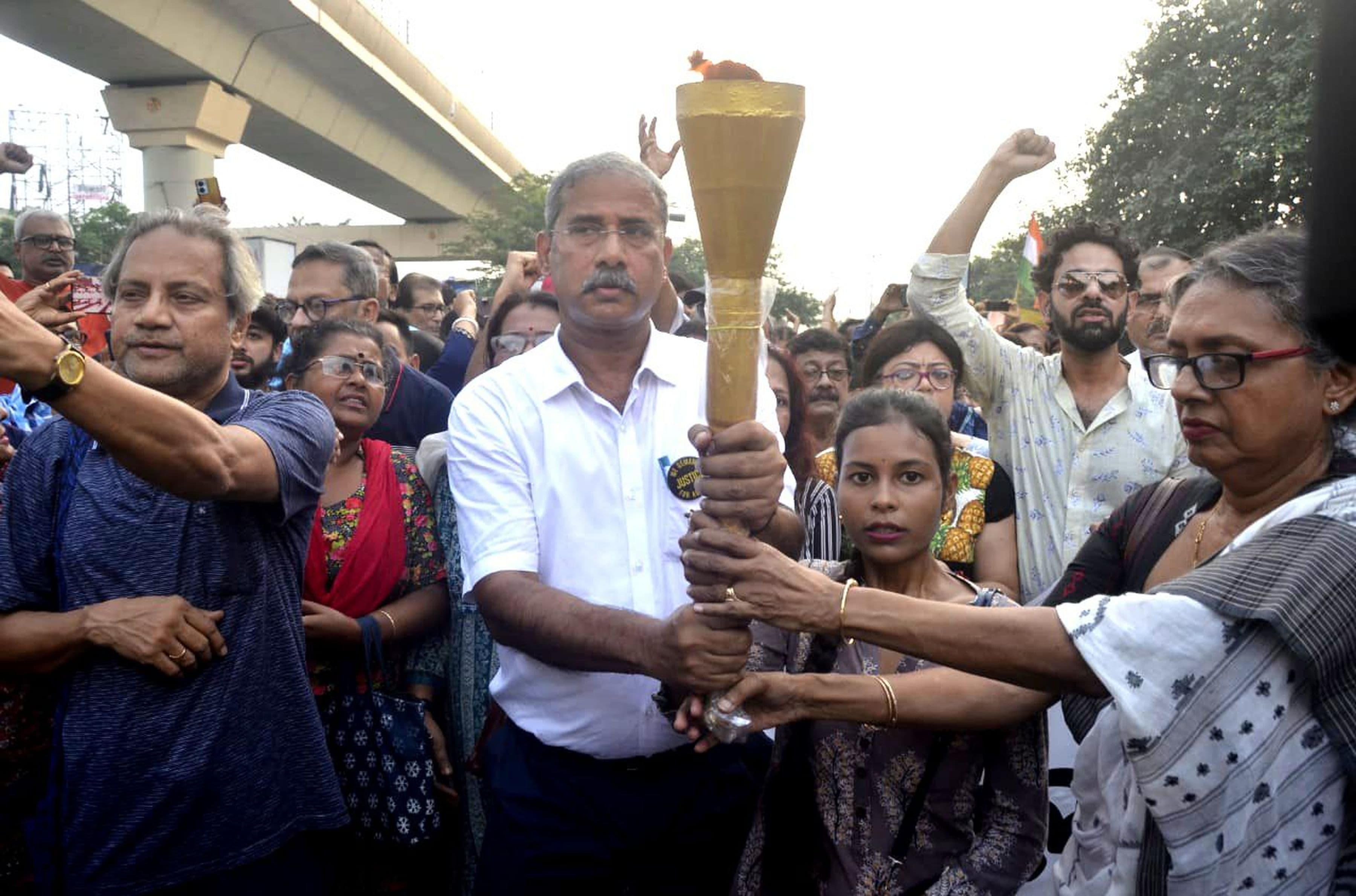 कोलकाता के दक्षिणी हिस्से में स्थित हाईलैंड पार्क से निकाली गई मशाल रैली में इंसाफ की आवाज बुलंद करते लोग।